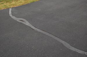 Asphalt driveway crack filled with hot pour crack filler and sealed